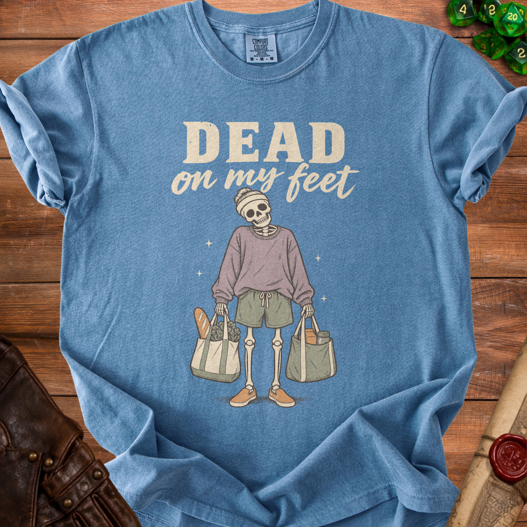 Skeleton graphic with "DEAD on my feet" text on a blue t-shirt.