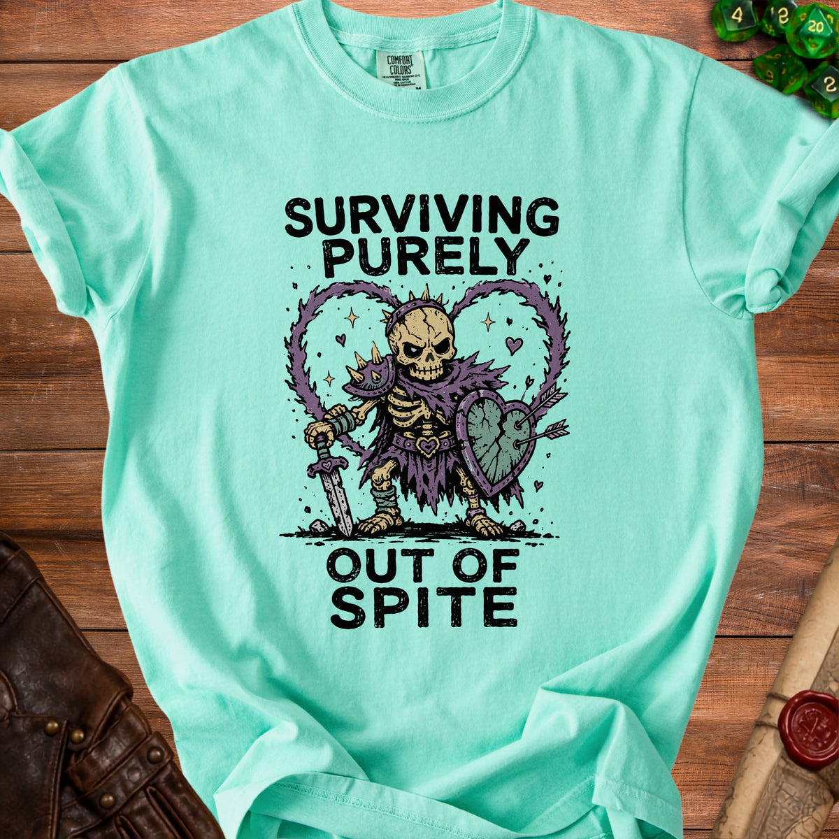 Mint green t-shirt with skeleton graphic and text "Surviving Purely Out Of Spite."
