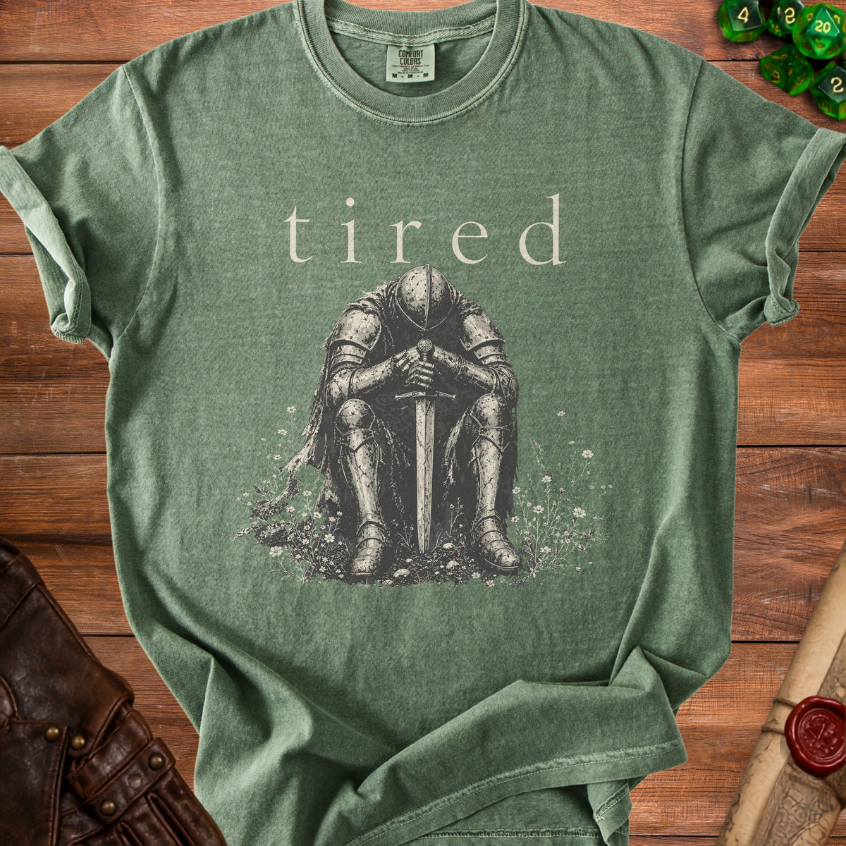 Green t-shirt with "tired" text above a knight sitting with sword.