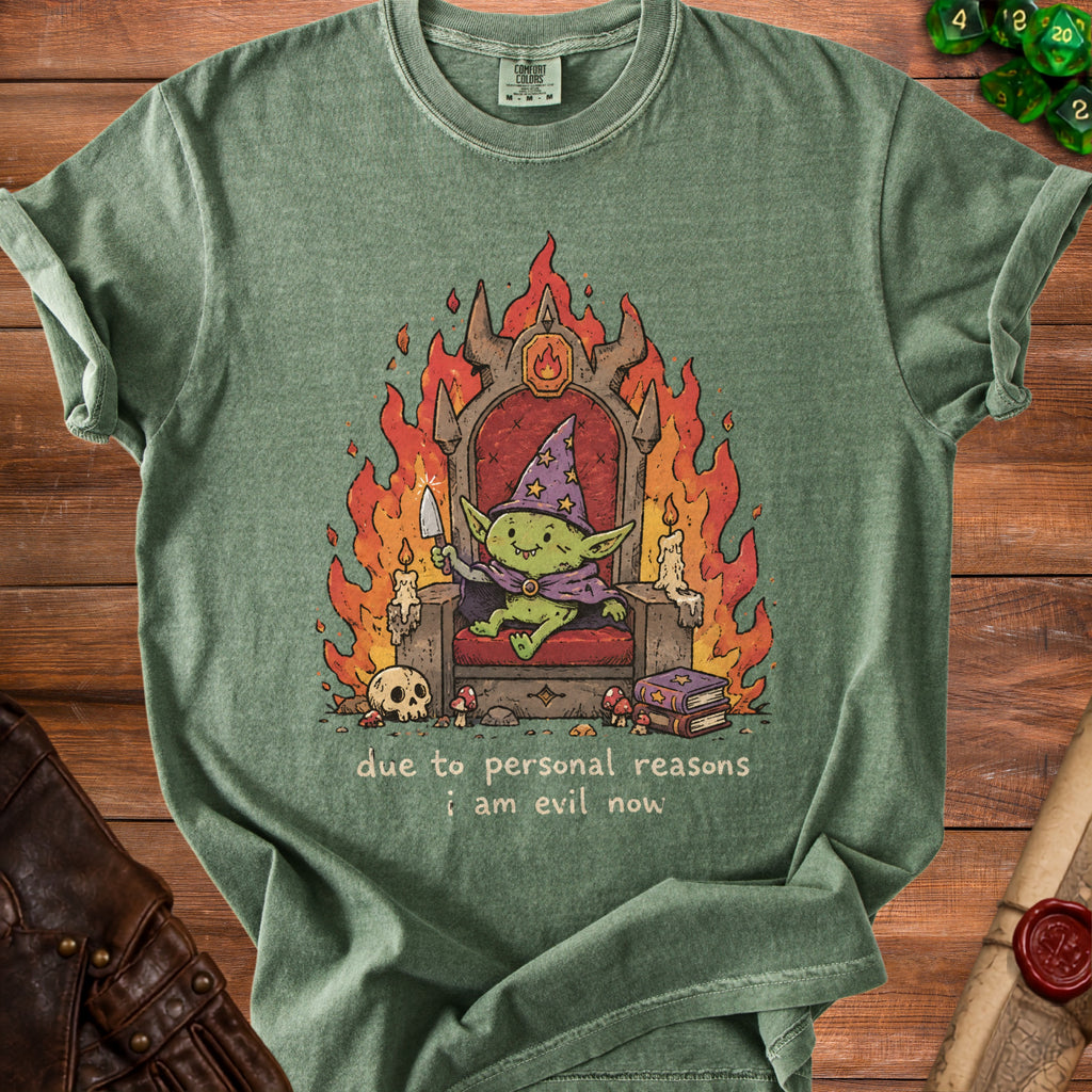 Green t-shirt with illustration of a goblin on a throne with flames and text "due to personal reasons i am evil now".