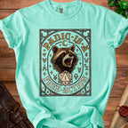 Mint green t-shirt with a raccoon, dice, and "Panic is Free Action" text.