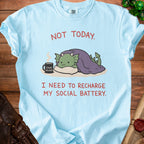 Light blue t-shirt with a cartoon dragon and text "Not Today. I Need to Recharge My Social Battery."