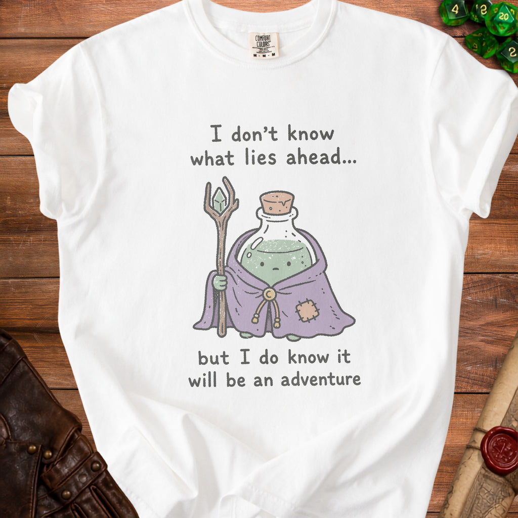 White t-shirt with potion and staff graphic, text "I don't know what lies ahead... but I do know it will be an adventure".