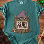 Teal t-shirt with goblin in tree stump saying "DO NOT PERCEIVE."