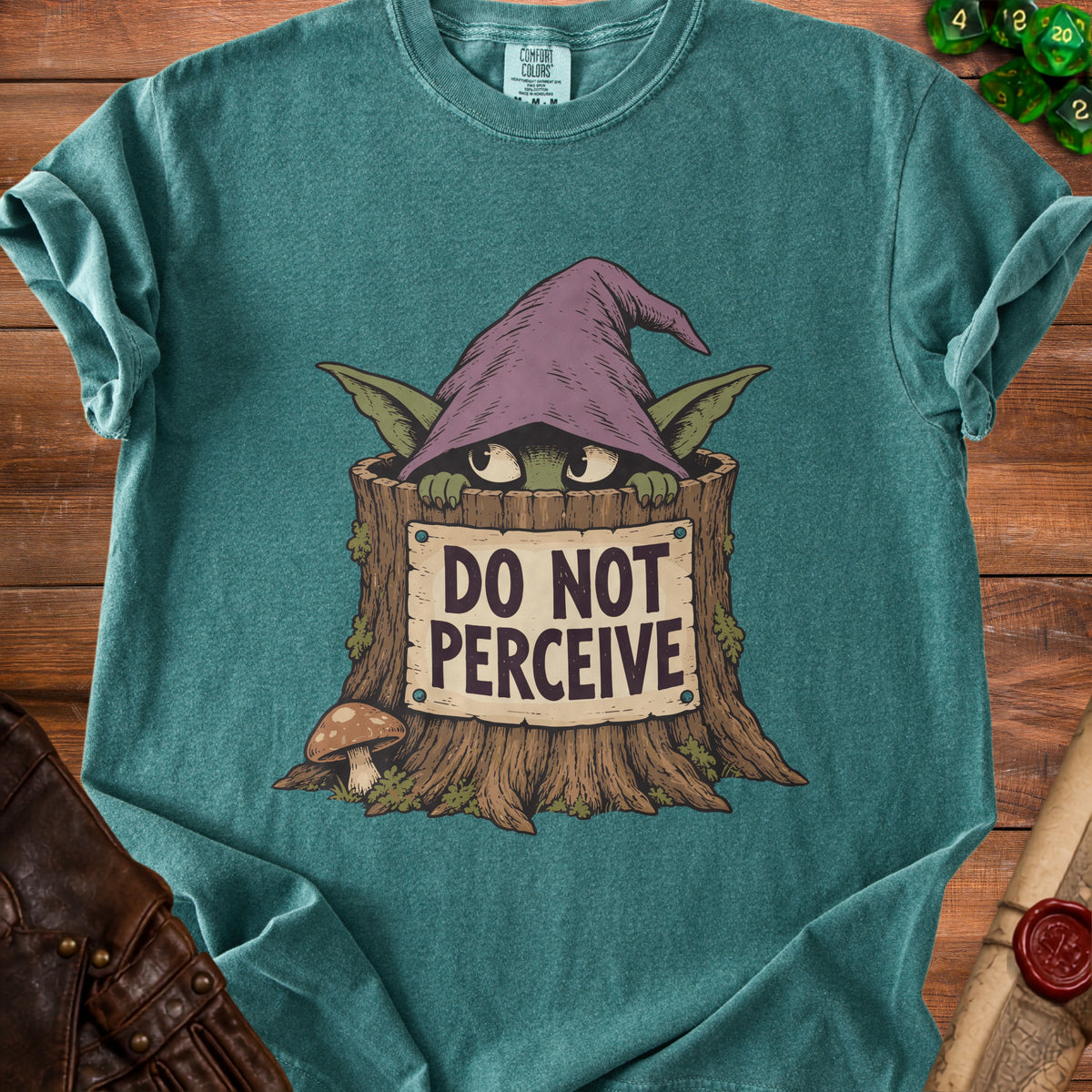 Teal t-shirt with goblin in tree stump saying "DO NOT PERCEIVE."