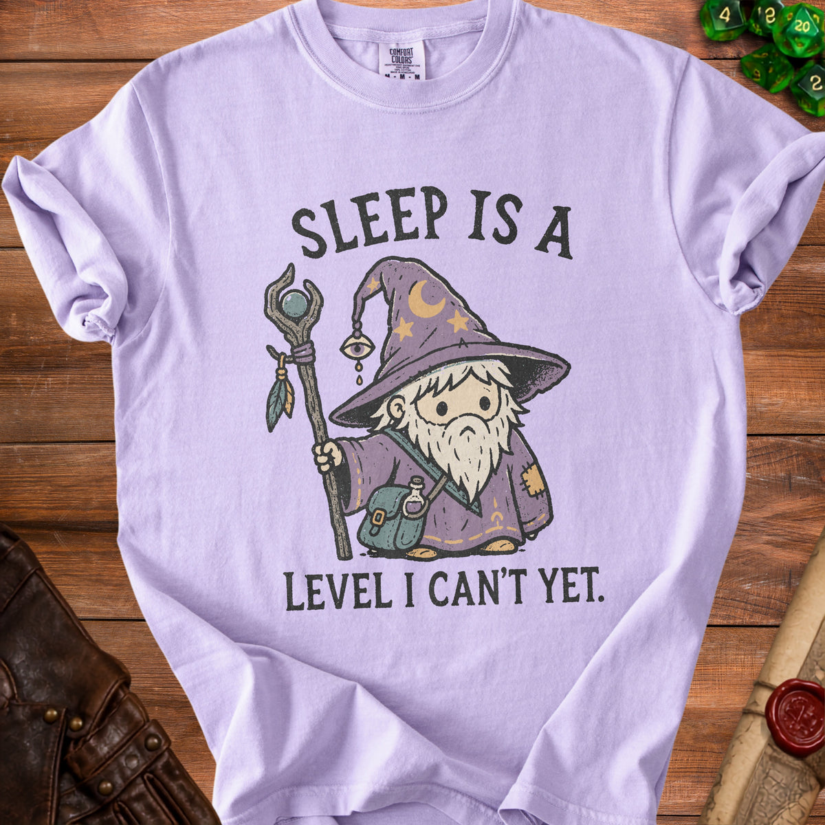 Purple t-shirt with graphic of wizard and text "SLEEP IS A LEVEL I CAN'T YET."