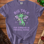 Purple t-shirt with a worried green dragon holding a flame, text reads "Big Talk for Someone in Fireball Range".