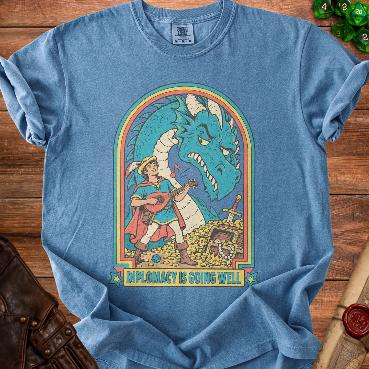 Blue t-shirt graphic: man playing lute before a dragon, chest of gold, text "DIPLOMACY IS GOING WELL".