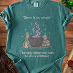 Teal t-shirt with witchy illustration and text "There is no secret The only thing you have to do is continue".