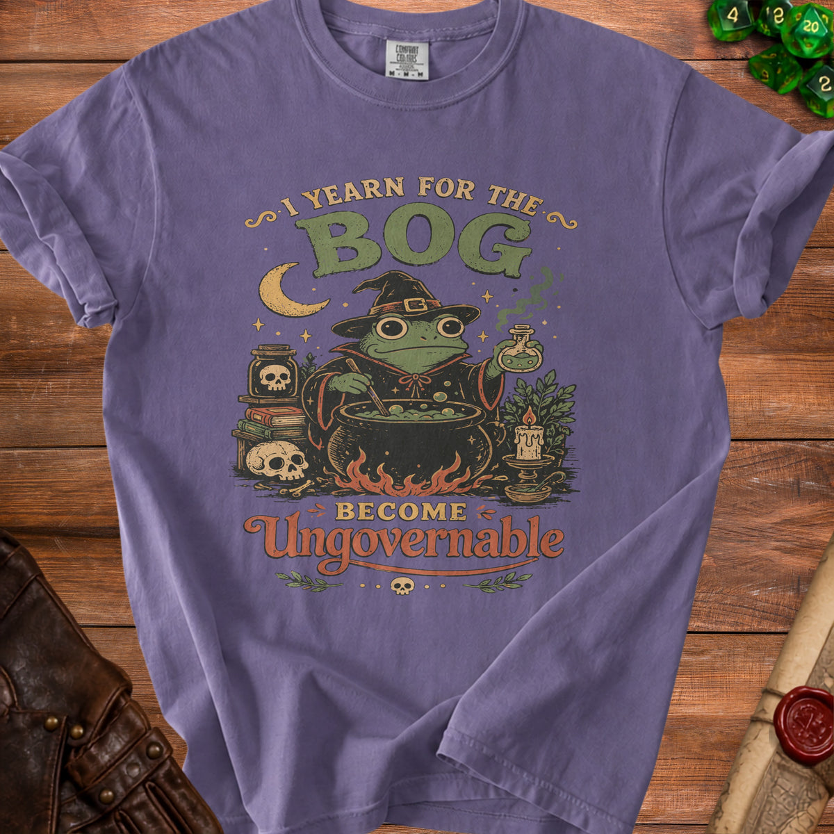 Purple t-shirt with frog witch and text "I YEARN FOR THE BOG BECOME Ungovernable".