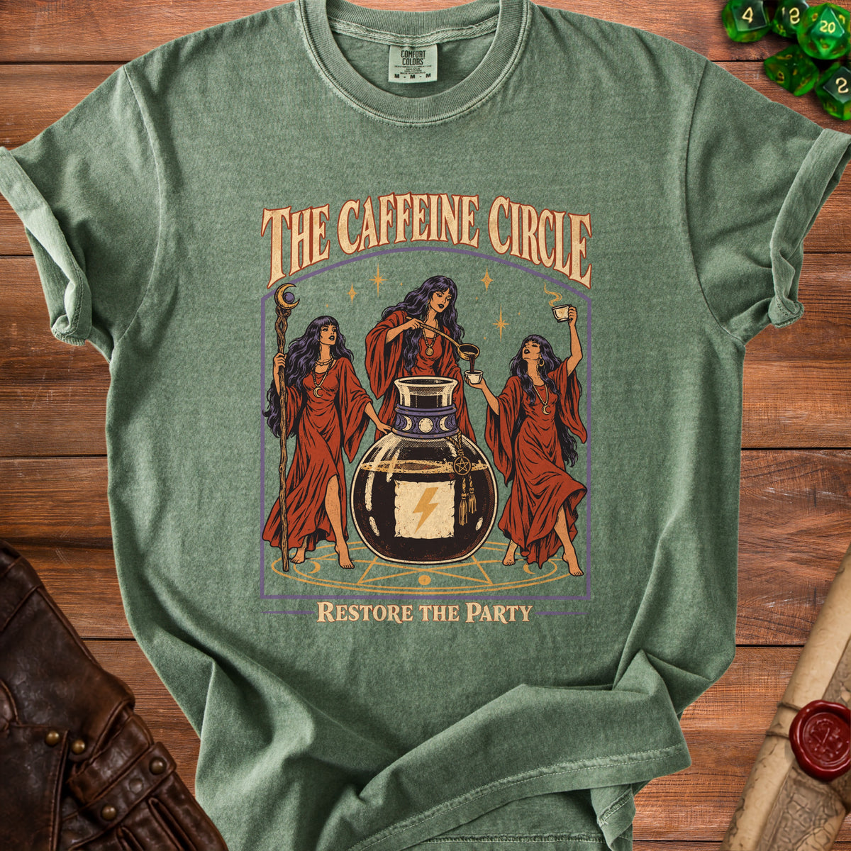 T-shirt graphic of three women around a cauldron with the text "The Caffeine Circle" and "Restore the Party".