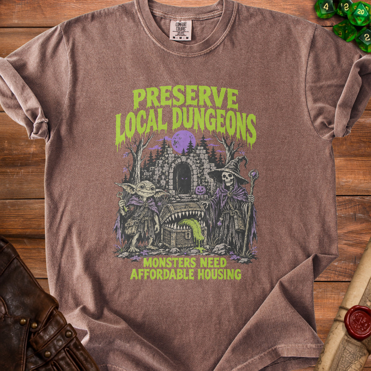 Brown t-shirt with "Preserve Local Dungeons" and "Monsters Need Affordable Housing" text.