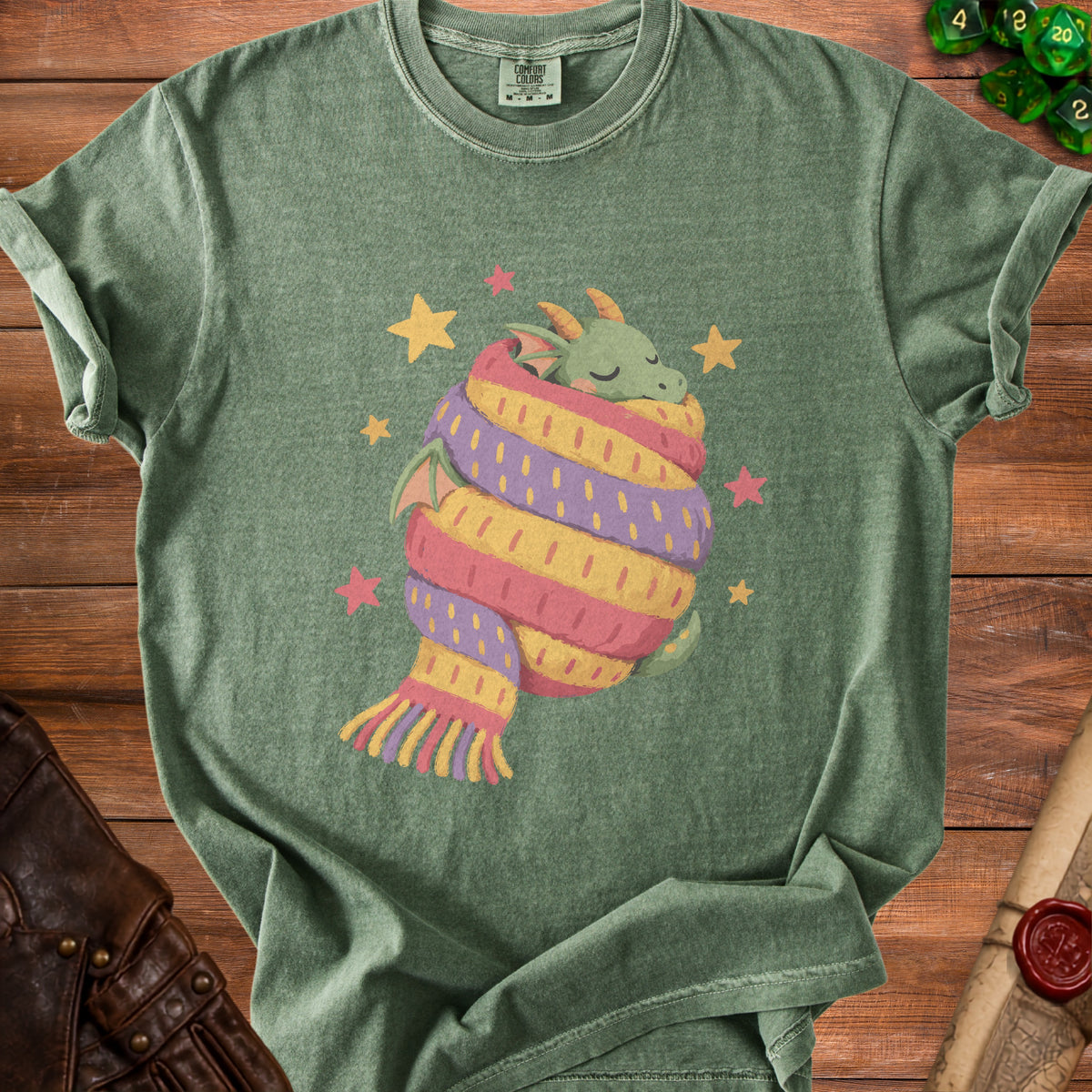 Green t-shirt with a sleeping dragon wrapped in a rainbow scarf and stars.