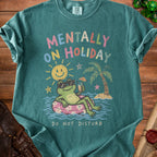 Green t-shirt with graphic of frog on inner tube saying "Mentally On Holiday Do Not Disturb".