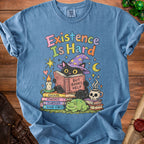 Blue t-shirt with a black cat in a witch hat reading "But Books Help."