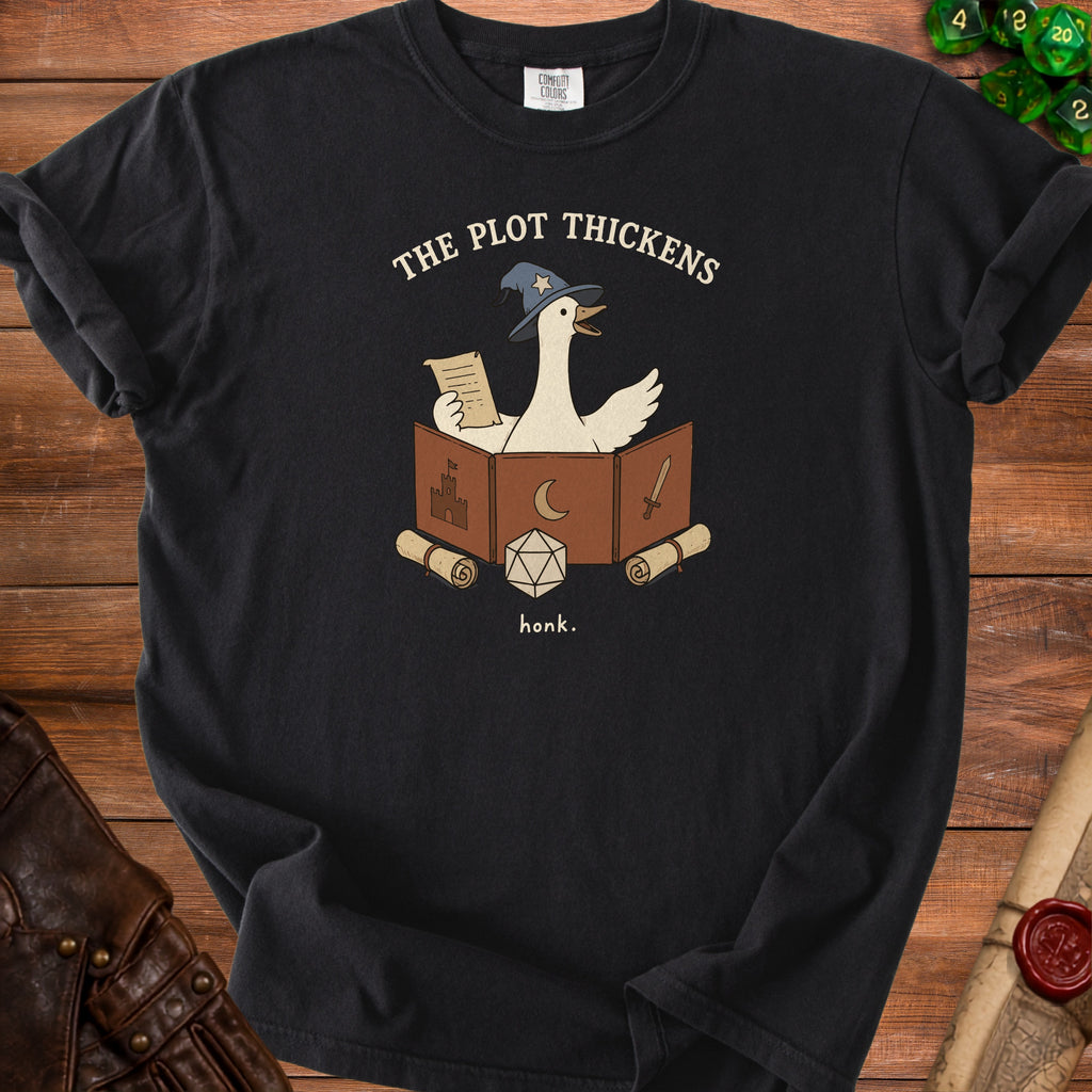 Black t-shirt with a cartoon goose in a wizard hat reading a scroll and the text "The Plot Thickens."