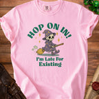 Pink t-shirt with skeleton wizard on broom, "Hop On In! I'm Late For Existing" text.