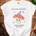 White t-shirt with cartoon mushroom wearing a wizard hat and text "plans? yeah, i have some... mostly canceling and snacks".