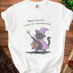 White t-shirt with a black cat wizard graphic and text "ABRACA ZOOOPY FEED ME HOOMAN FOOD".