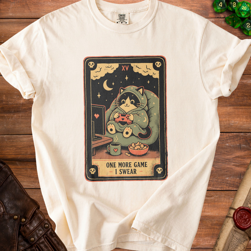 Cream t-shirt with a tarot card design of a cat playing a video game.