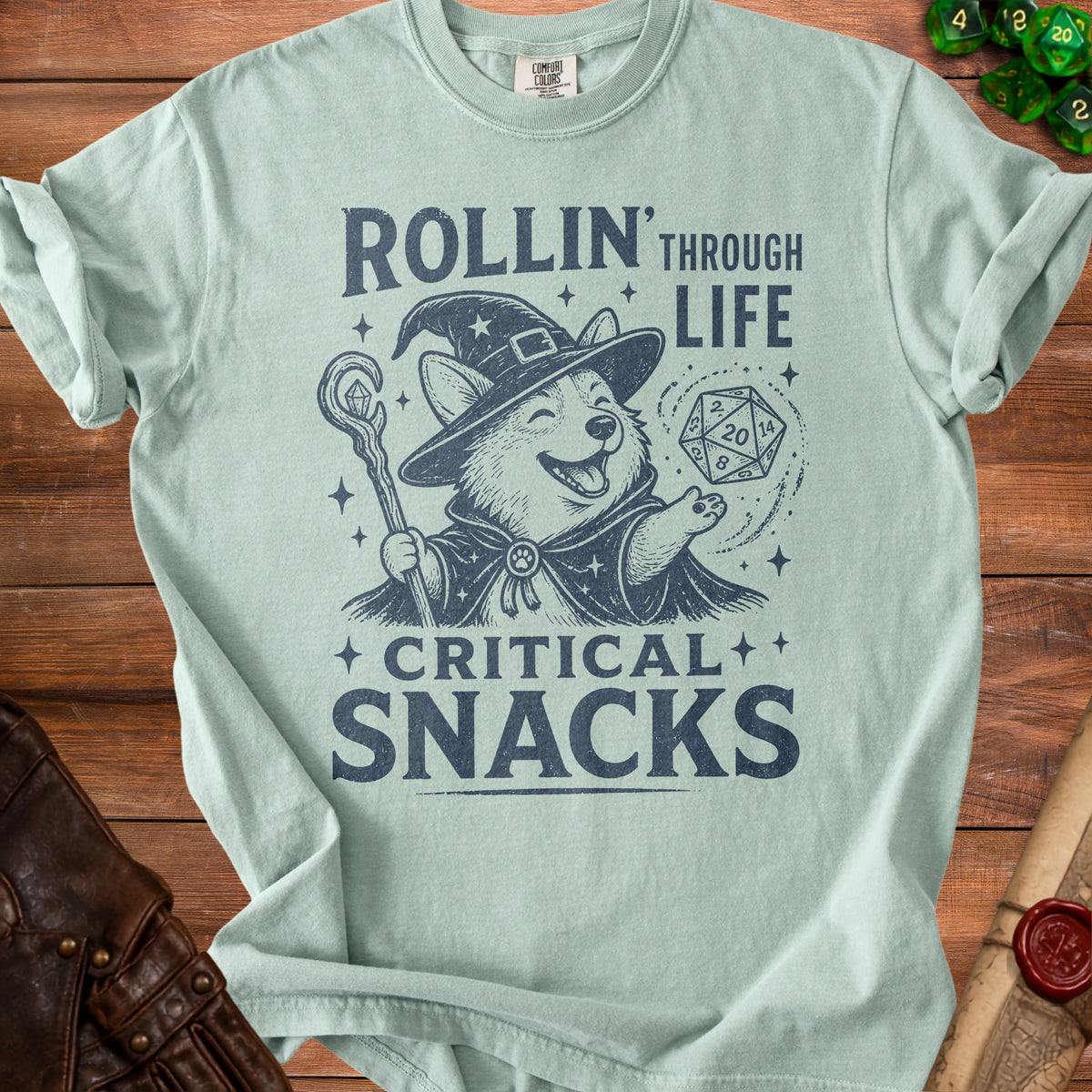 Light blue t-shirt with a corgi wizard and the text "Rollin' Through Life Critical Snacks".