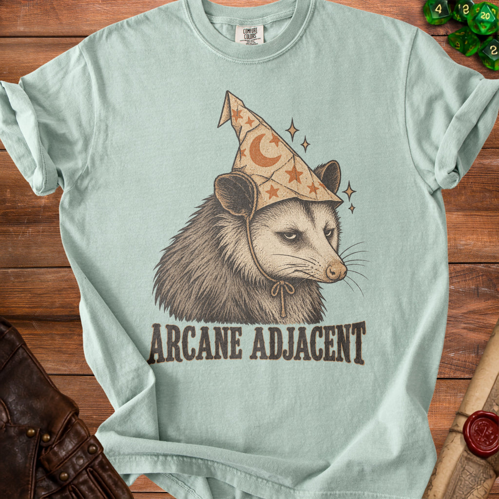 Opossum wearing a wizard hat with moons and stars, text "ARCANE ADJACENT".