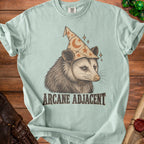 Opossum wearing a wizard hat with moons and stars, text "ARCANE ADJACENT".