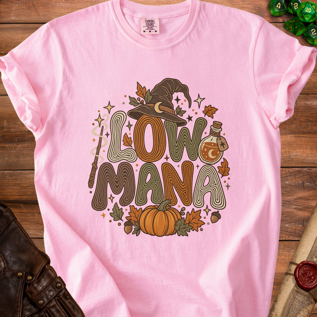 Pink t-shirt with "Low Mana" text, witch hat, pumpkin, potion, and fall leaves graphic.