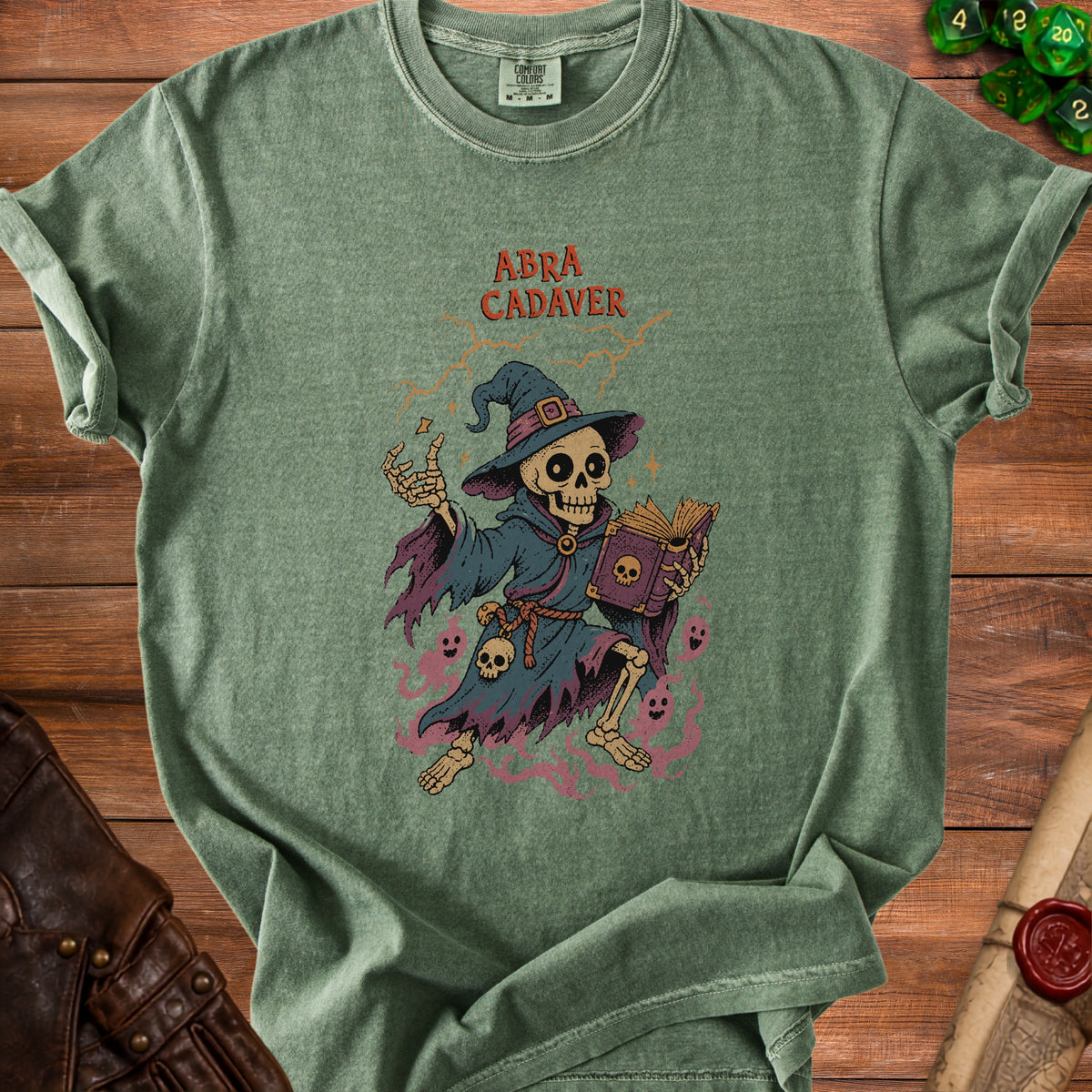 Green t-shirt with a skeleton wizard and text "Abra Cadaver" printed on it.