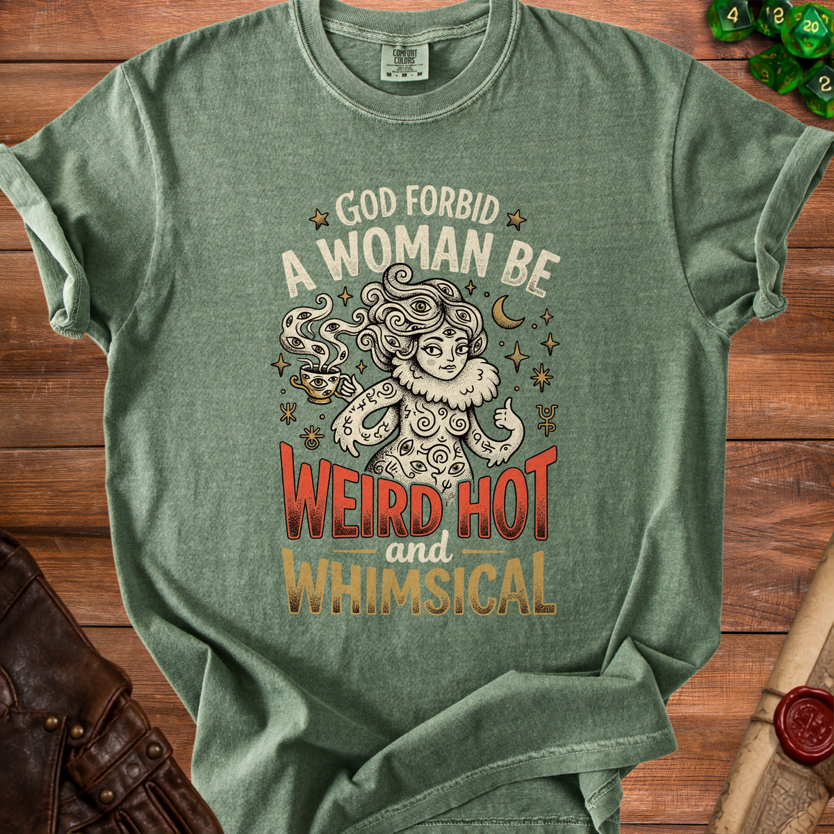 Green t-shirt with "God Forbid A Woman Be Weird Hot and Whimsical" text and mystical illustration.