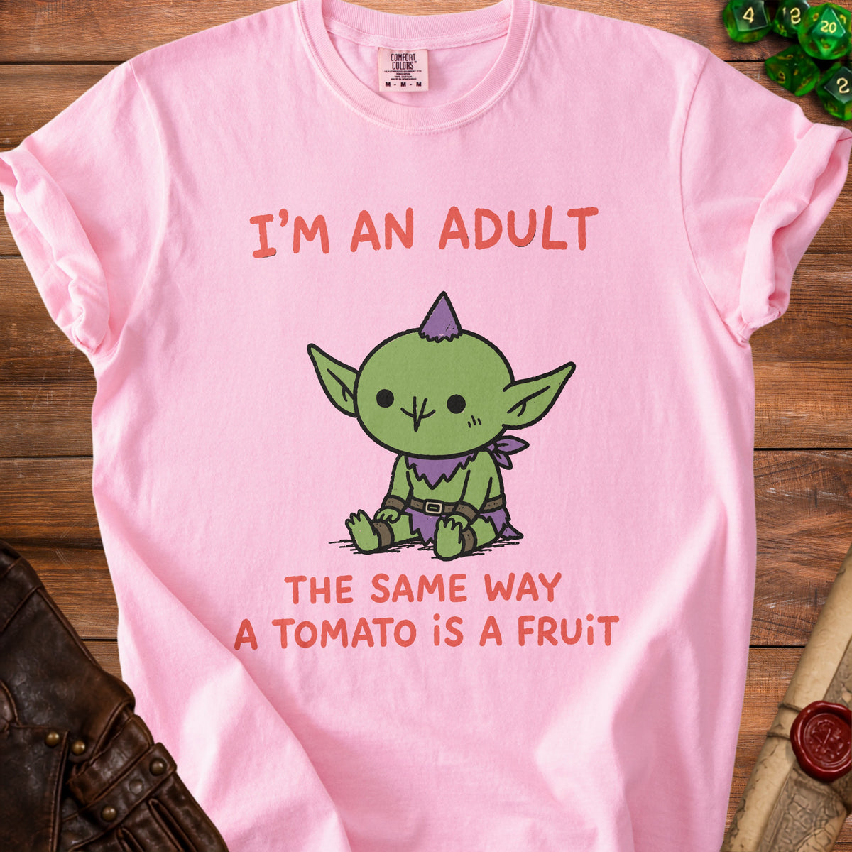 Pink t-shirt with "I'M AN ADULT" and a cartoon goblin saying "THE SAME WAY A TOMATO IS A FRUIT".