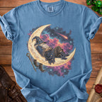 Blue t-shirt with a wizard sleeping on a crescent moon in a starry sky.