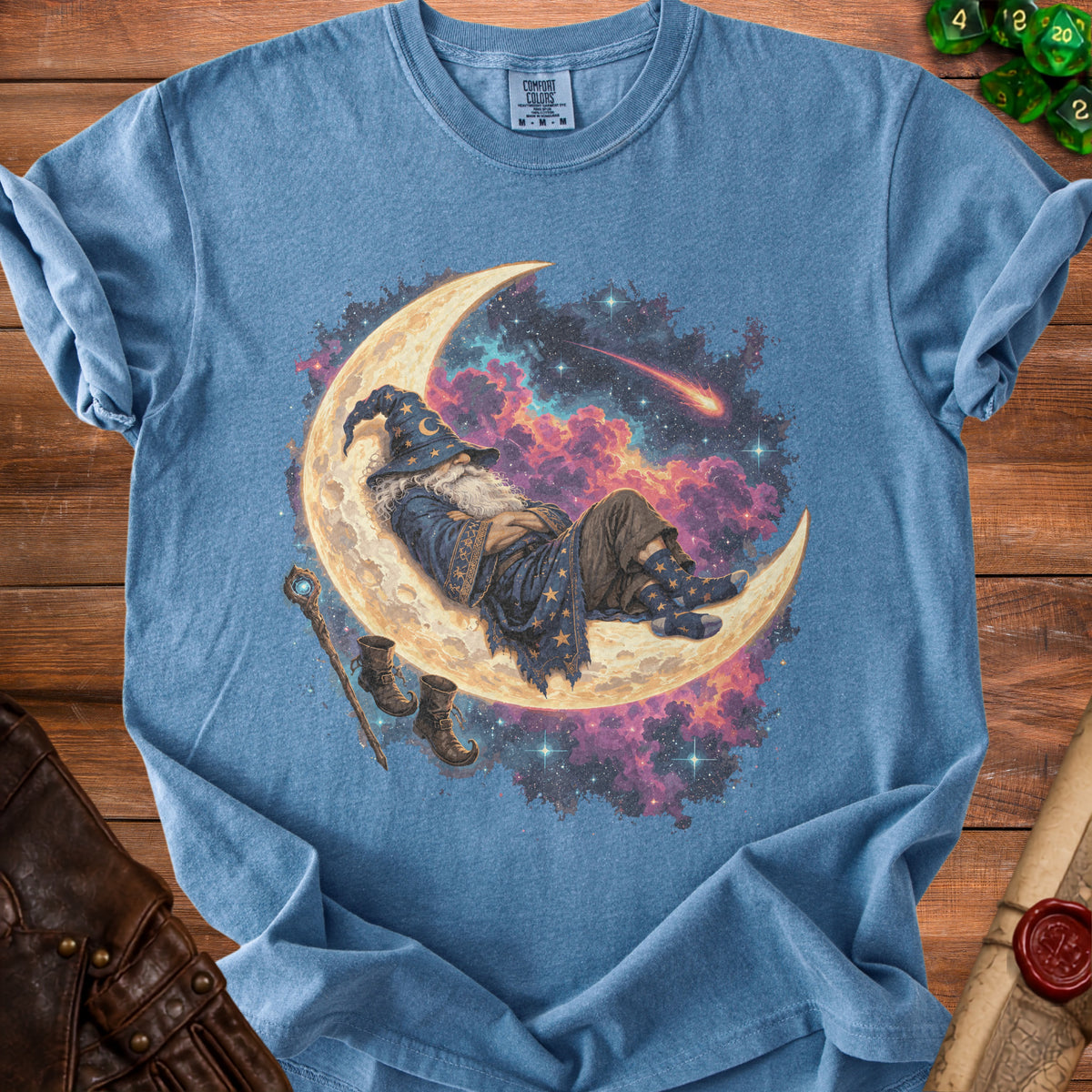 Blue t-shirt with a wizard sleeping on a crescent moon in a starry sky.