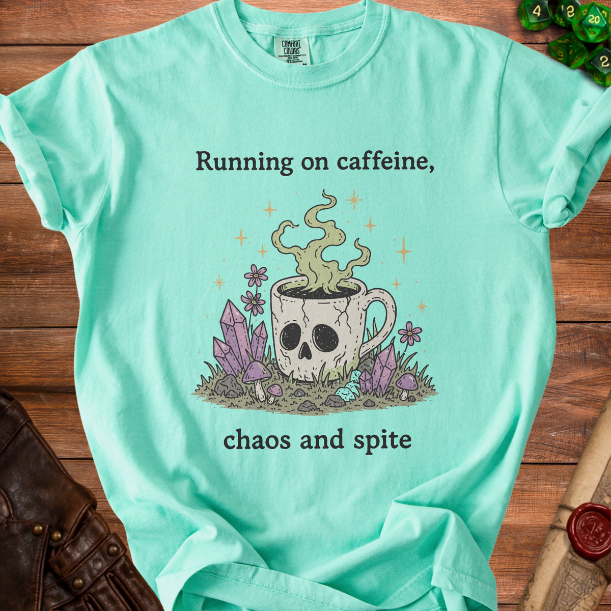 Teal t-shirt with skull coffee cup, crystals, and text "Running on caffeine, chaos and spite".