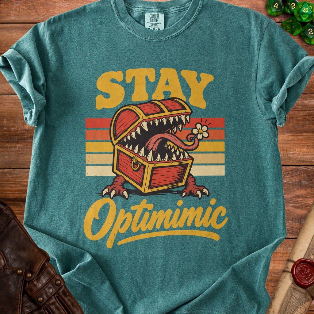 Teal t-shirt with "STAY Optimimic" text and a monster treasure chest.