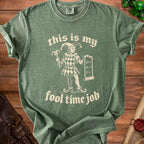 Green t-shirt with "this is my fool time job" text and a jester graphic.