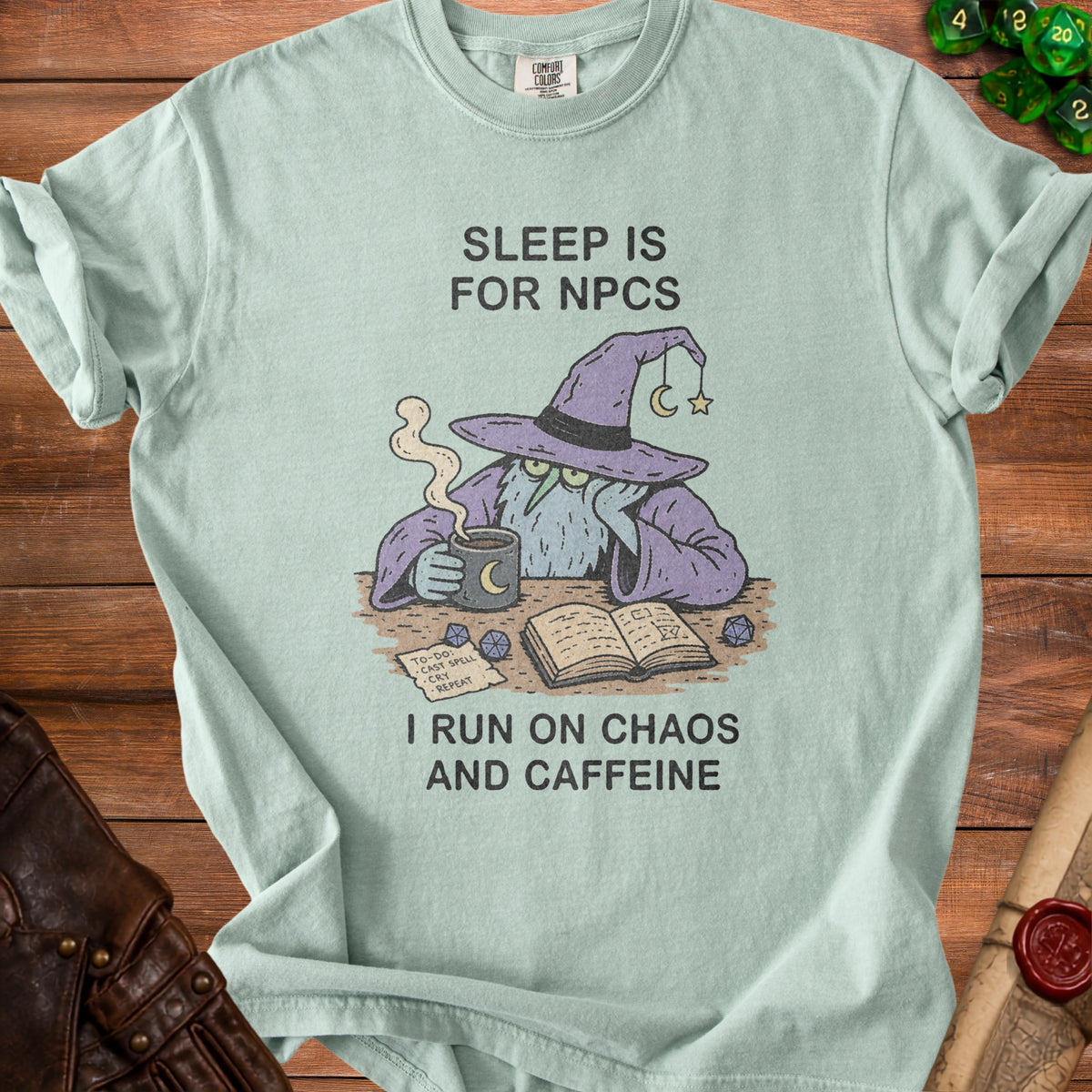 Light blue t-shirt with a wizard, coffee, and text: "Sleep is for NPCs. I run on Chaos and Caffeine."