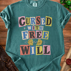 Teal t-shirt with "Cursed with Free Will" in colorful block letters and a broken compass.