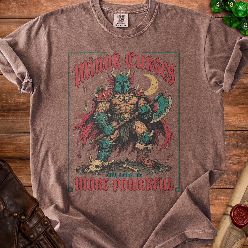 Brown t-shirt with "Minor Curses Only Make Me More Powerful" warrior graphic.