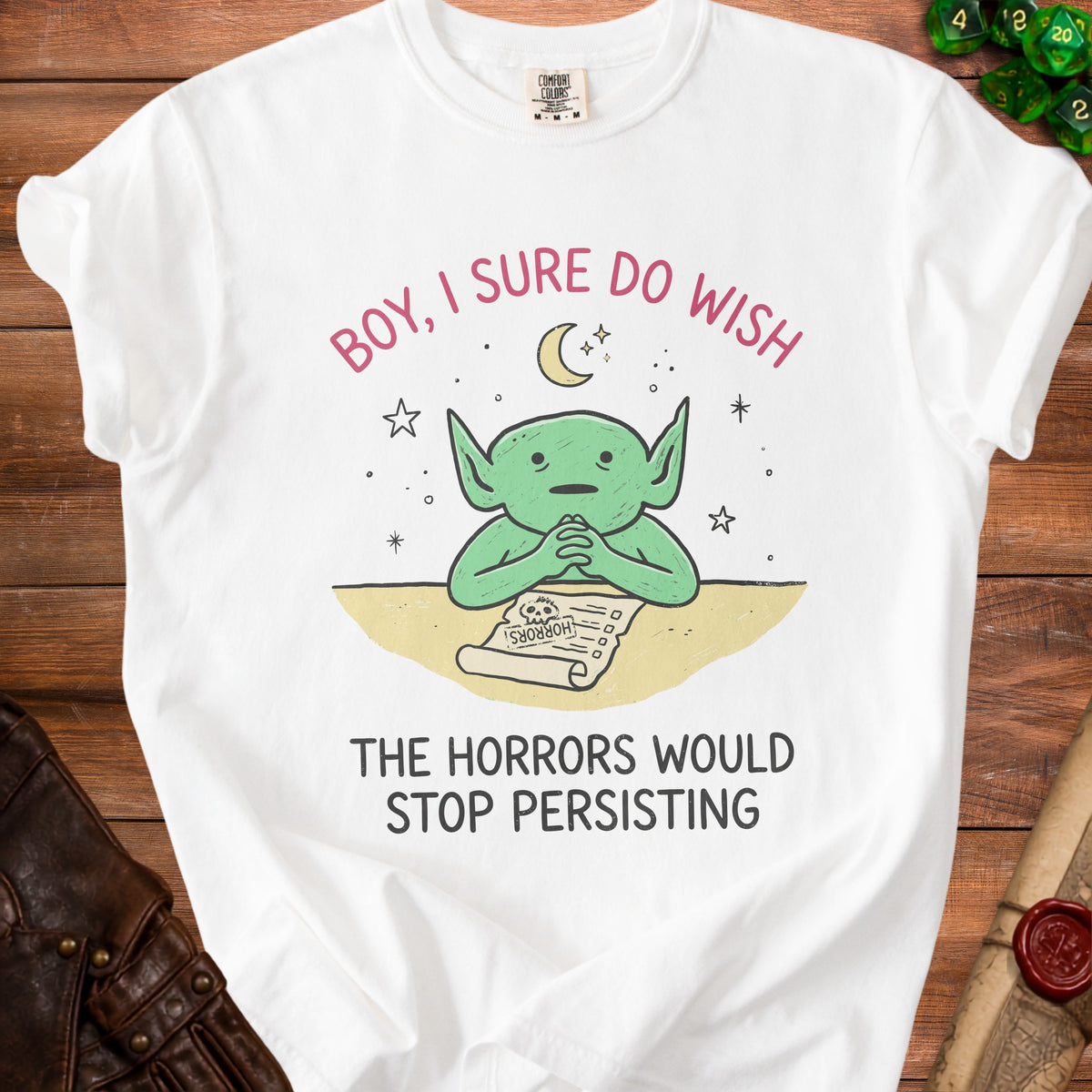 White t-shirt with green creature wishing for horrors to stop persisting.