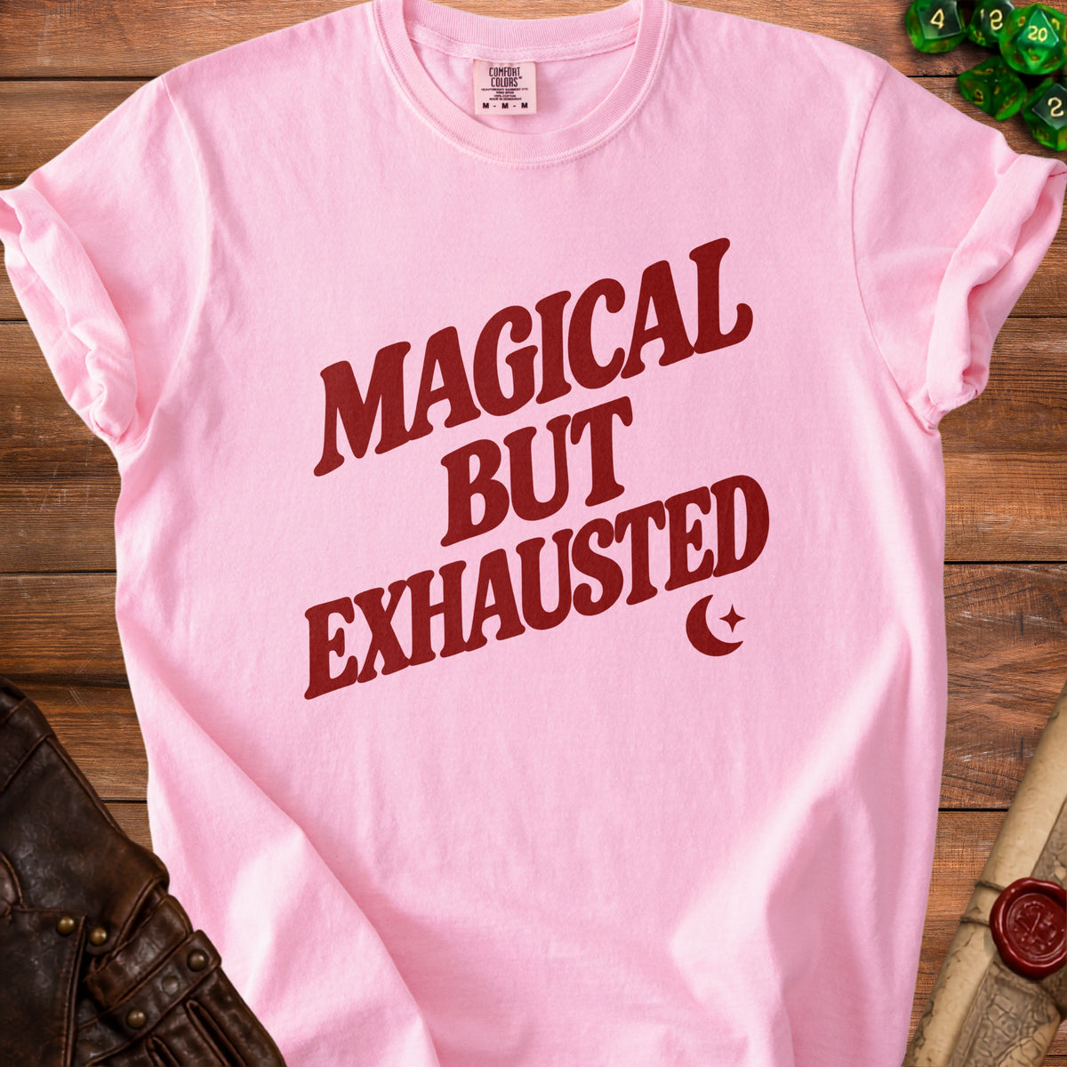 Pink t-shirt with red text reading "Magical But Exhausted" and a crescent moon.