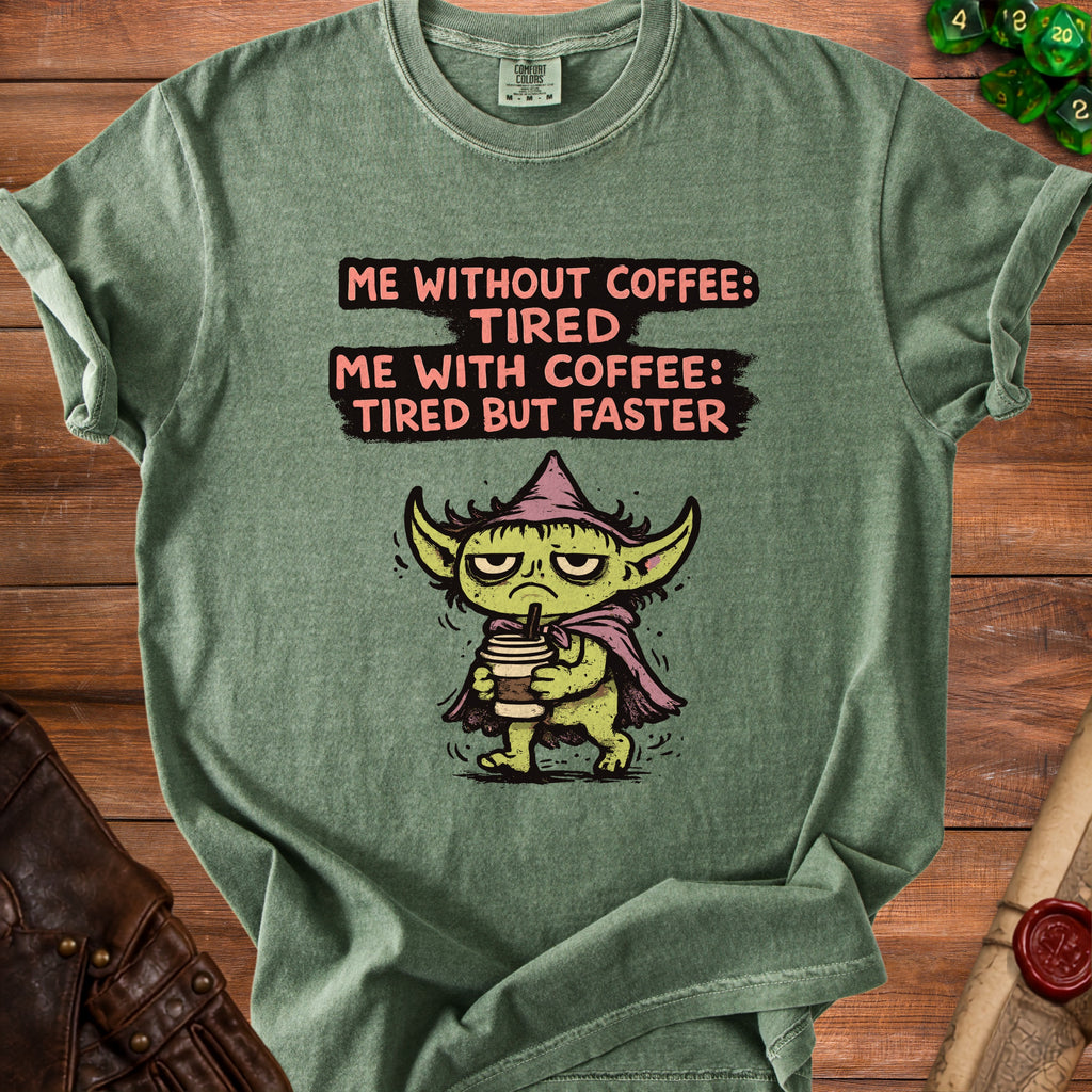 Green t-shirt with illustration of a goblin holding coffee and text "Me without coffee: Tired. Me with coffee: Tired but faster."