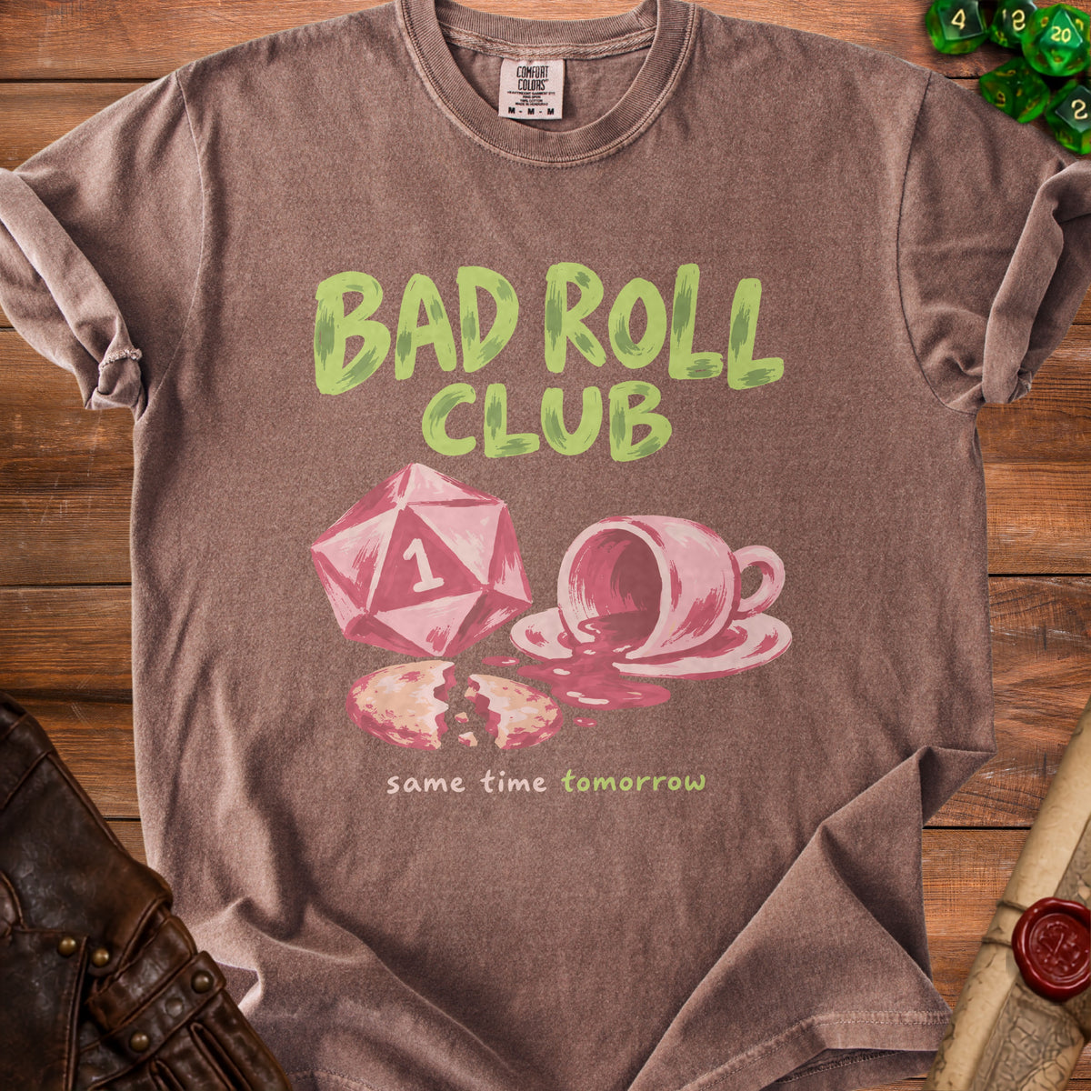 Brown t-shirt with "BAD ROLL CLUB" and spilled coffee over broken cookie.