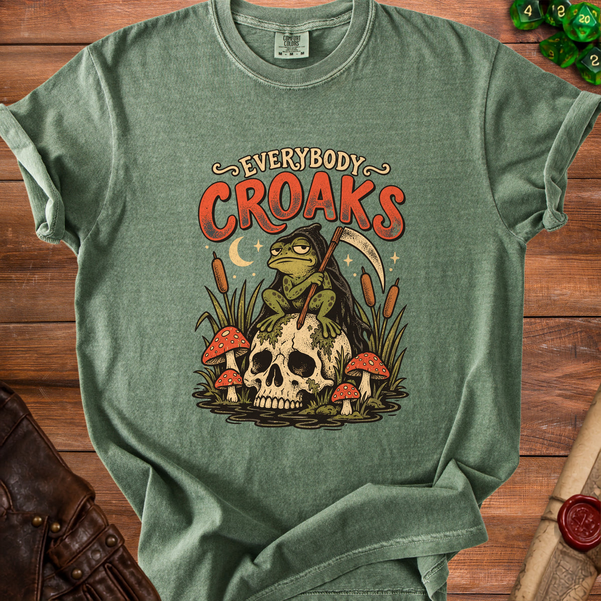Green t-shirt with a grim reaper frog on a skull graphic and "Everybody Croaks" text.