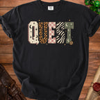 Black t-shirt with the word QUEST in patterned block letters and dice graphics.