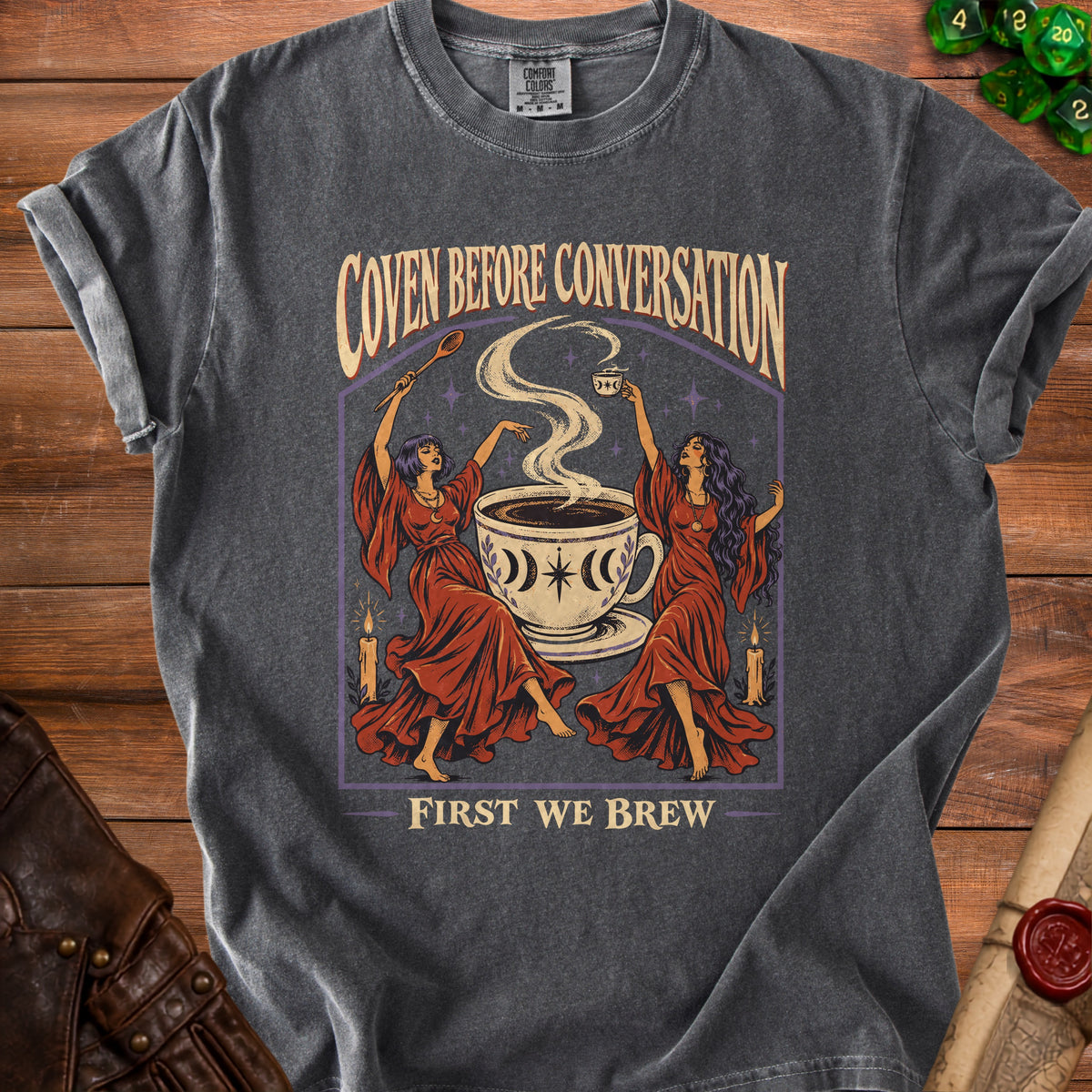 Dark grey t-shirt with "Coven Before Conversation, First We Brew" text and witchy coffee art.