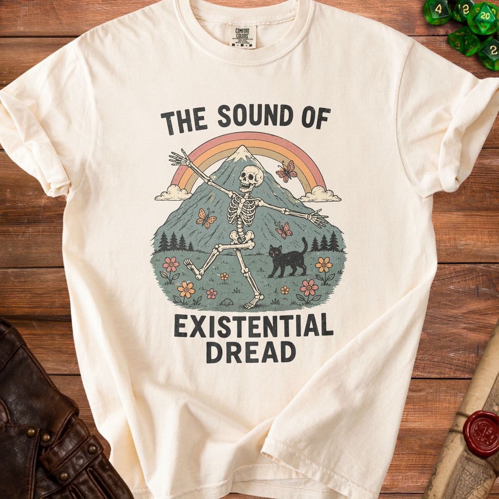 T-shirt with a skeleton, cat, butterflies, mountains, and rainbow graphic. Text reads "The Sound of Existential Dread."