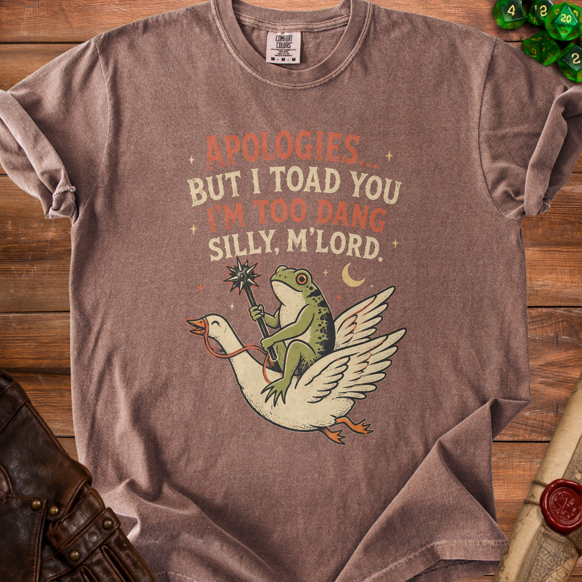 Brown t-shirt with text "APOLOGIES BUT I TOAD YOU I'M TOO DANG SILLY, M'LORD." and illustration.