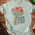 Light blue t-shirt with bouquet, d20 dice, scroll, key, and text "Bring Me Flowers & Side Quests".