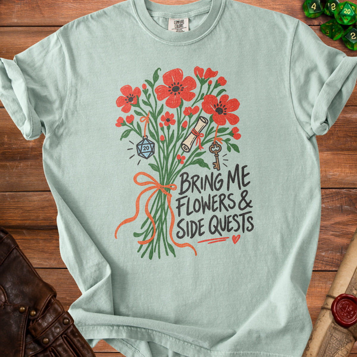 Light blue t-shirt with bouquet, d20 dice, scroll, key, and text "Bring Me Flowers & Side Quests".